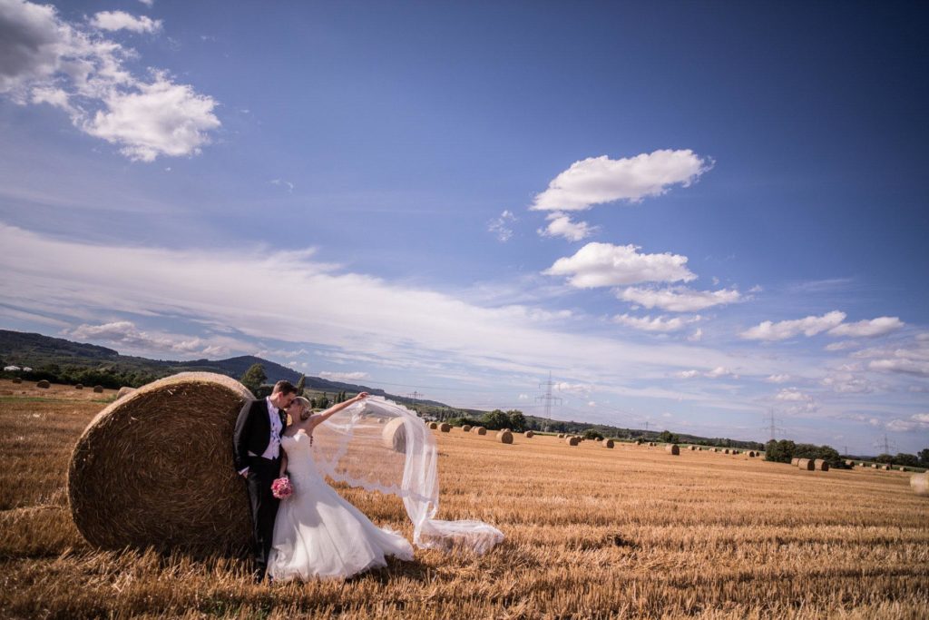 Hochzeitsfotograf Freiburg Umgebung Paarshooting Brautpaarkuss auf dem Feld