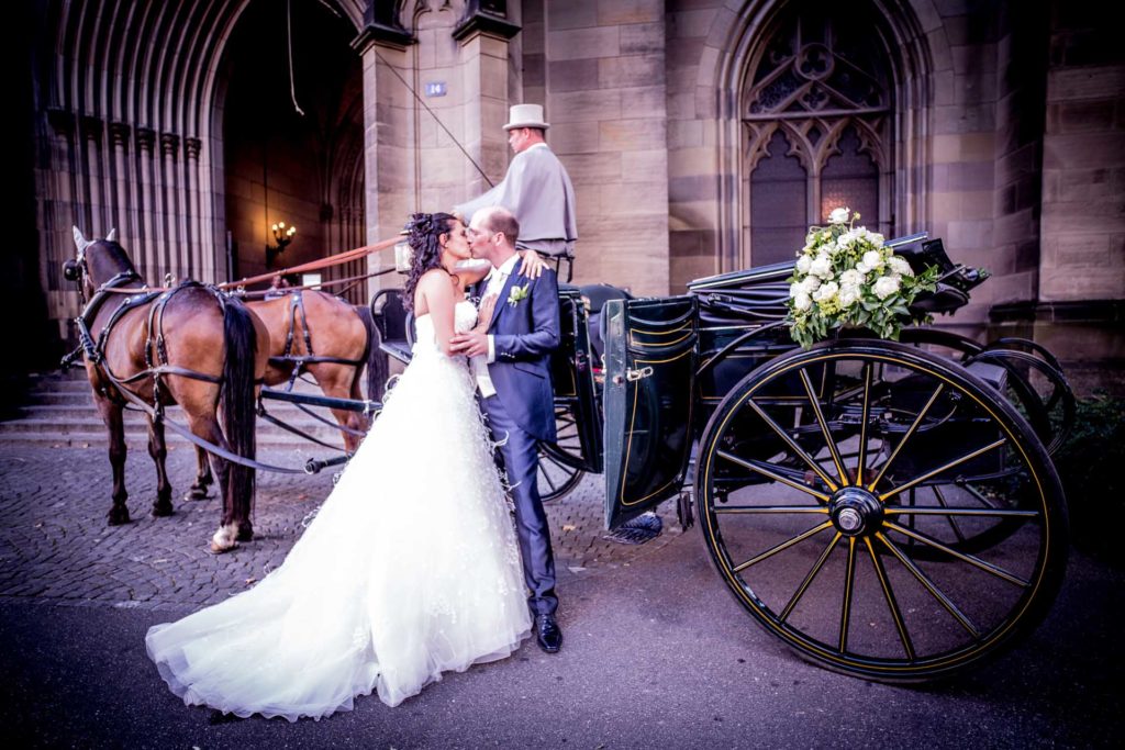 Hochzeitsfotografie Hochzeitsvideo Freiburg Basel braut und Bräutigam küssen sich vor Elisabethenkirche
