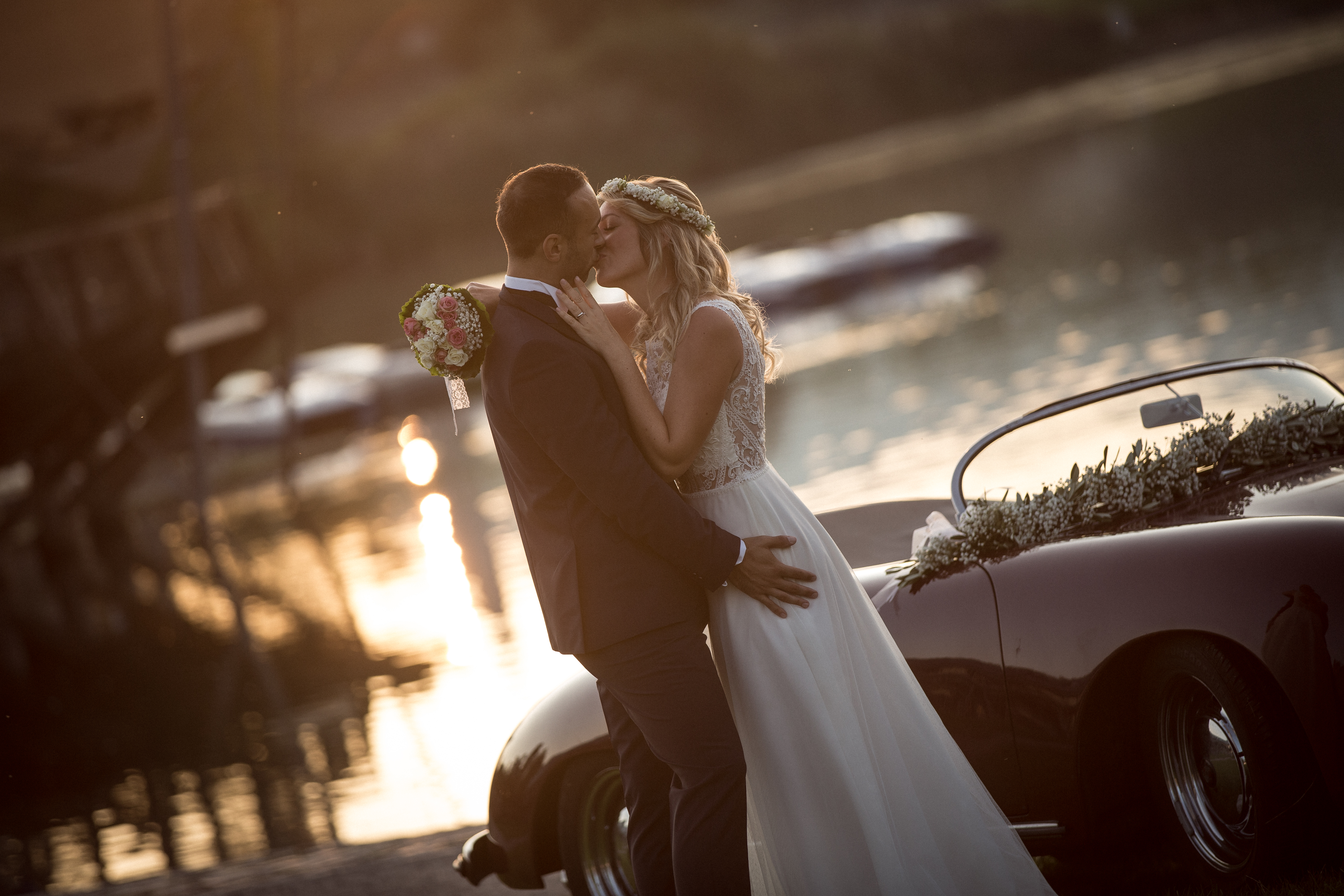 Hochzeitsfotograf_freiburg_basel_zuerich_portraitshooting_sonnenaufgang_paar_kuesst_auto_seepark